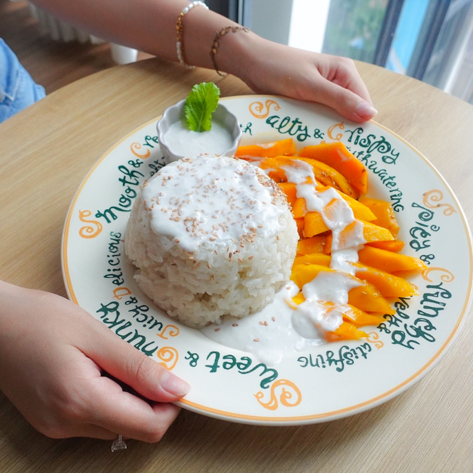 Two hands holding a plate of today's recipe.