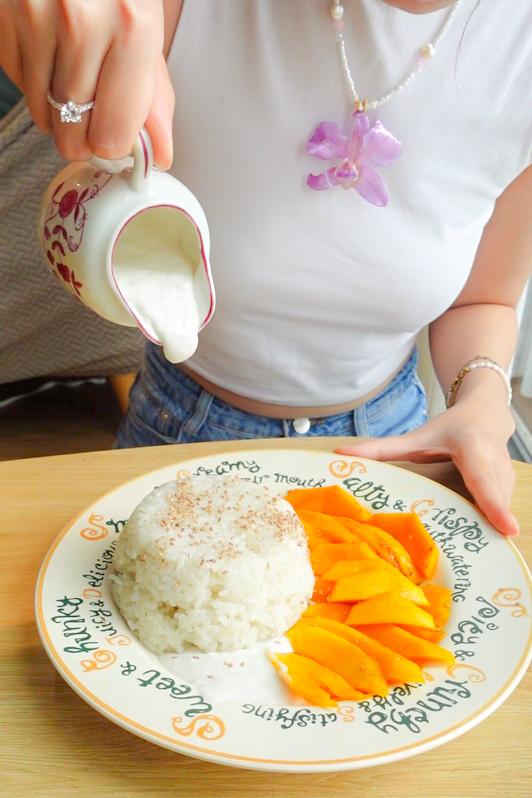 Pouring the coconut sauce onto the final plate of Mango Sticky Rice.
