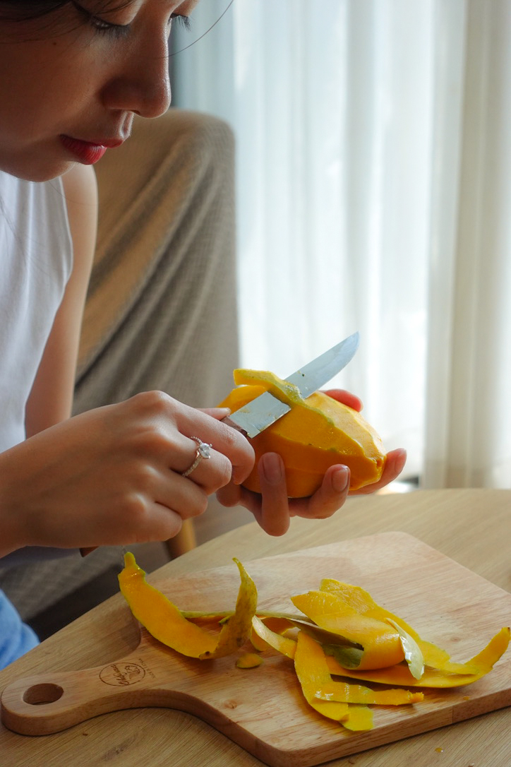 A person is peeling mango