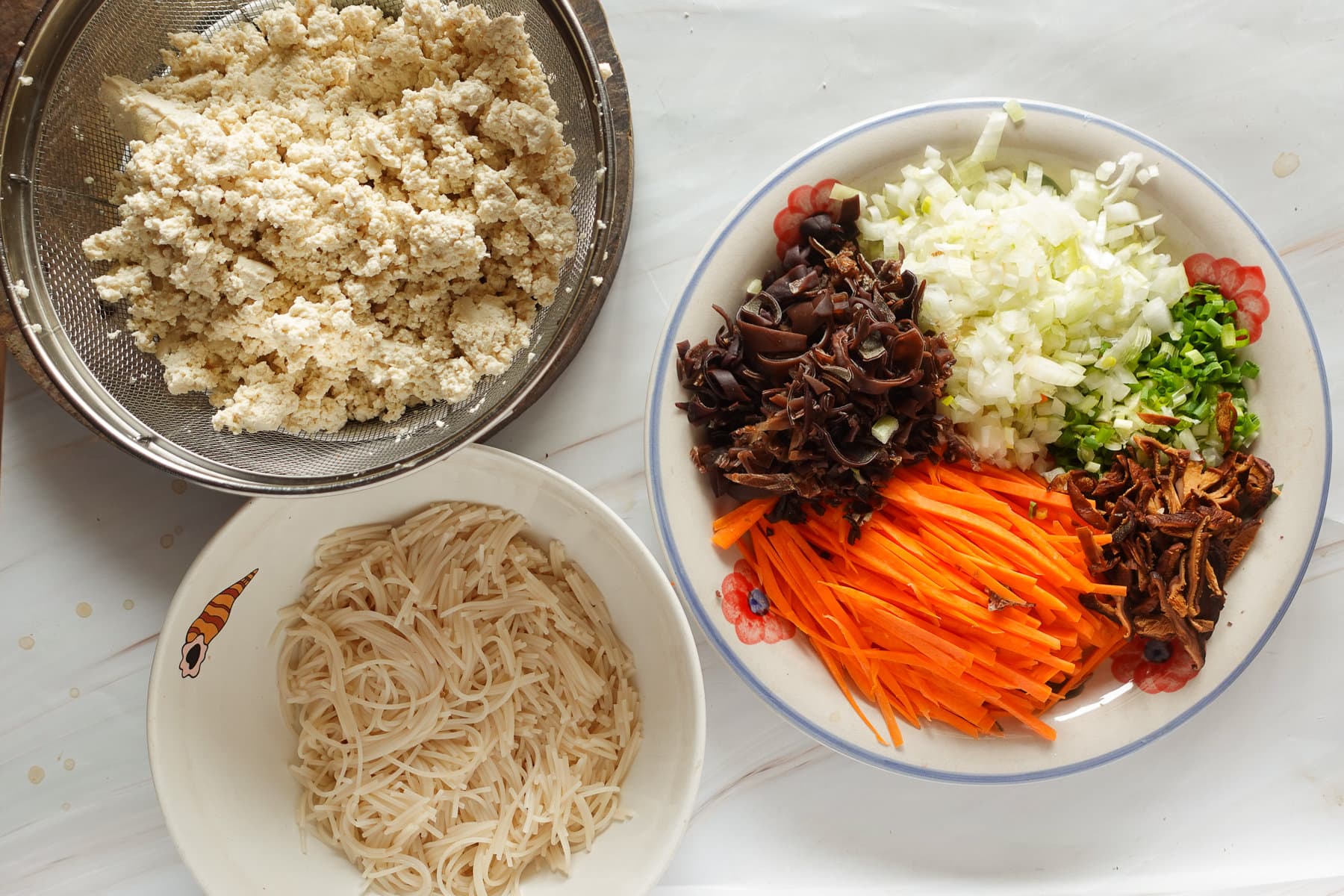 Prepare the ingredients: mushrooms, onion, green onion, carrot, tofu, glass noodles