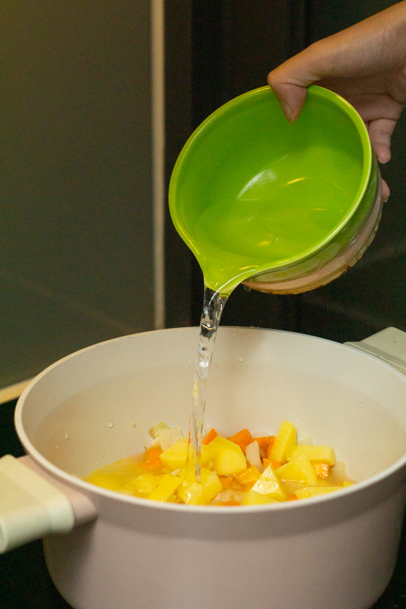 pouring water in the pot to make a broth