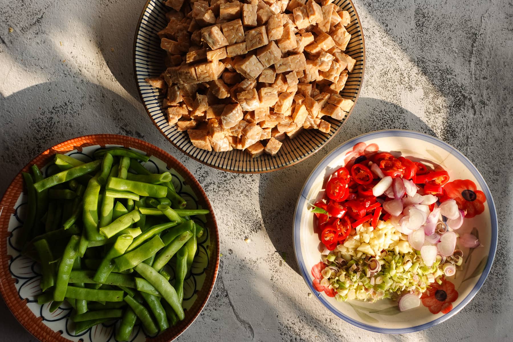 Cut the tempeh, green beans and slice your aromatics