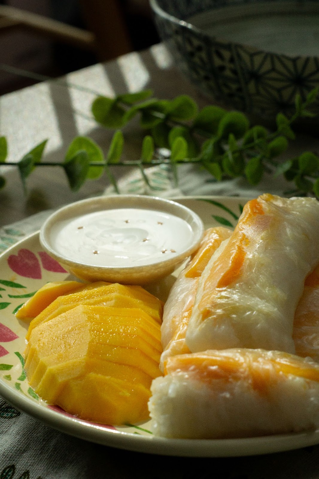 Mango Sticky Rice Spring Rolls on a plate with coconut sauce