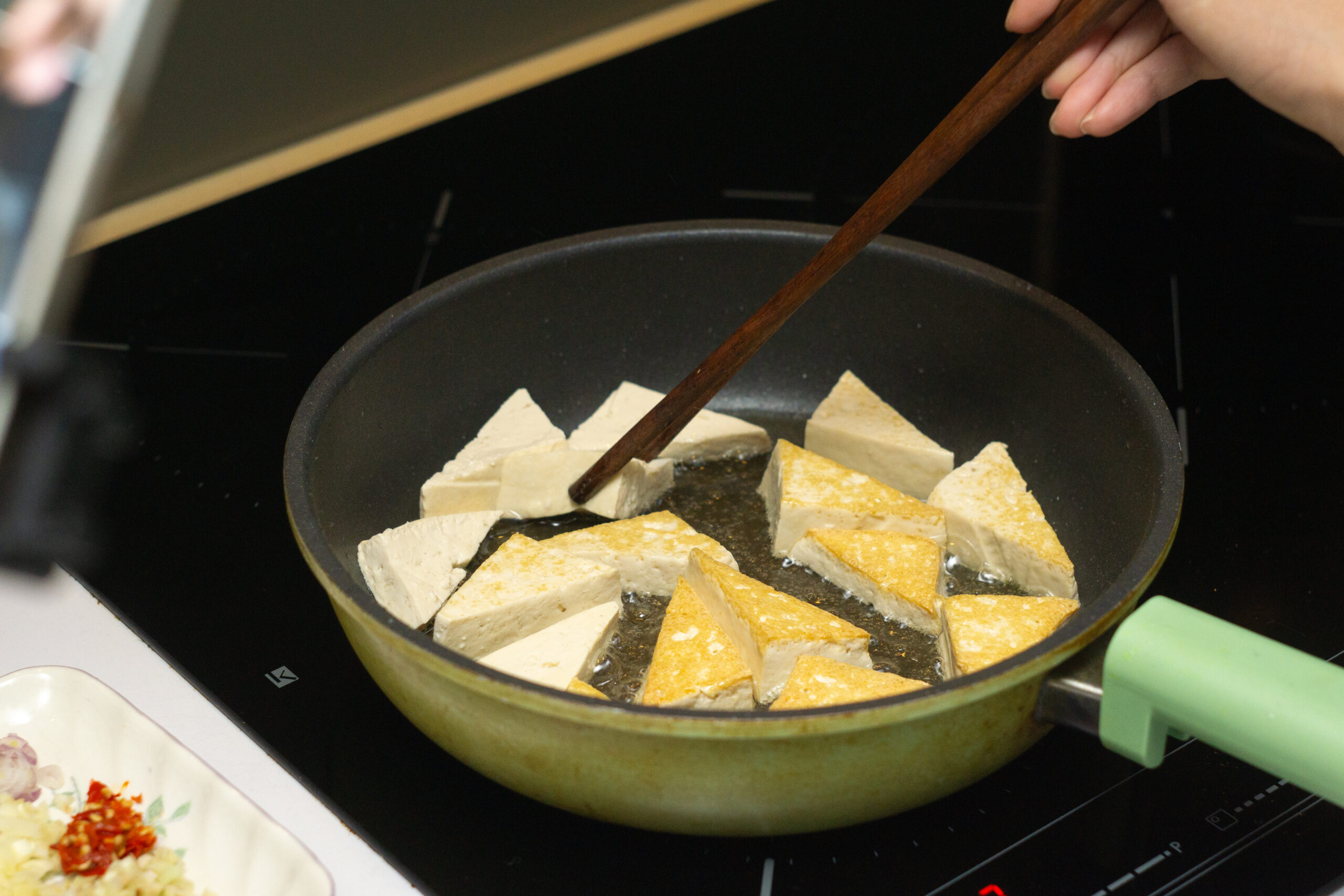 frying the tofu until golden