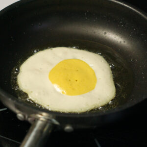 vegan fried egg in a sizzling pan