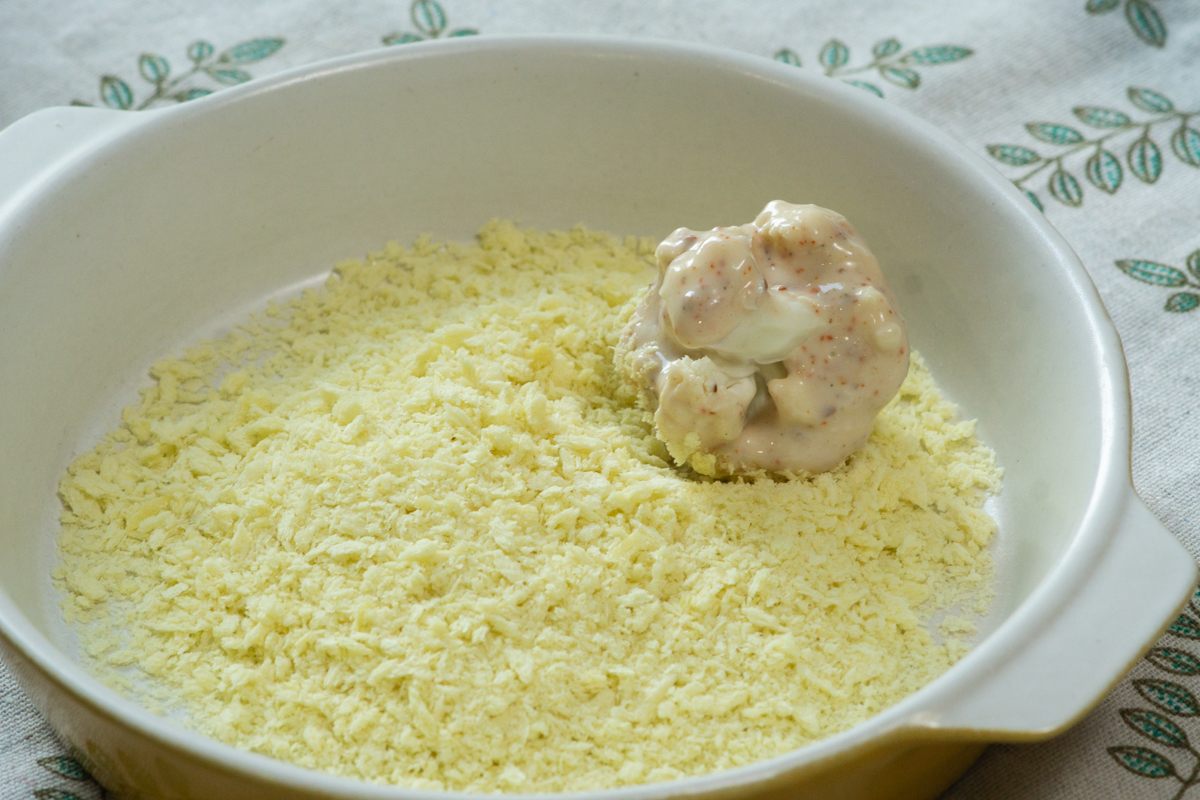 rolling the coated florets in breadcrumbs
