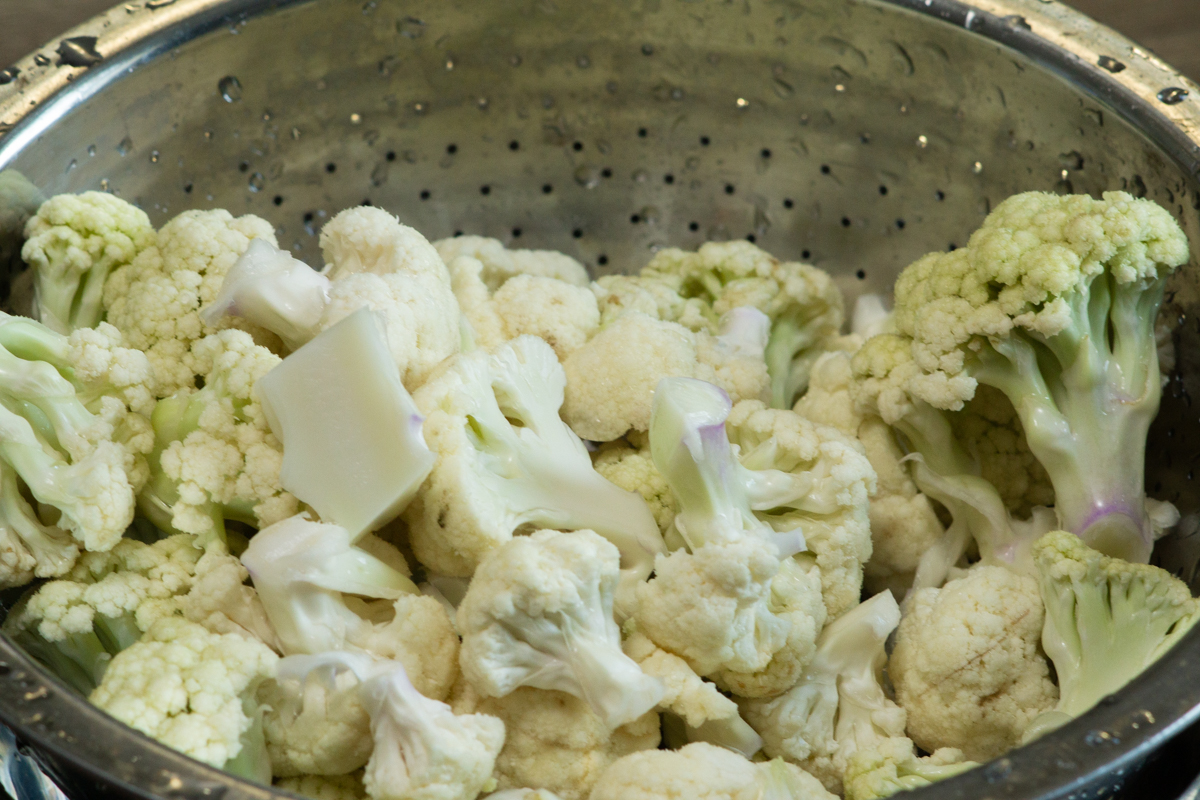 rinsing excess water off the cauliflower florets