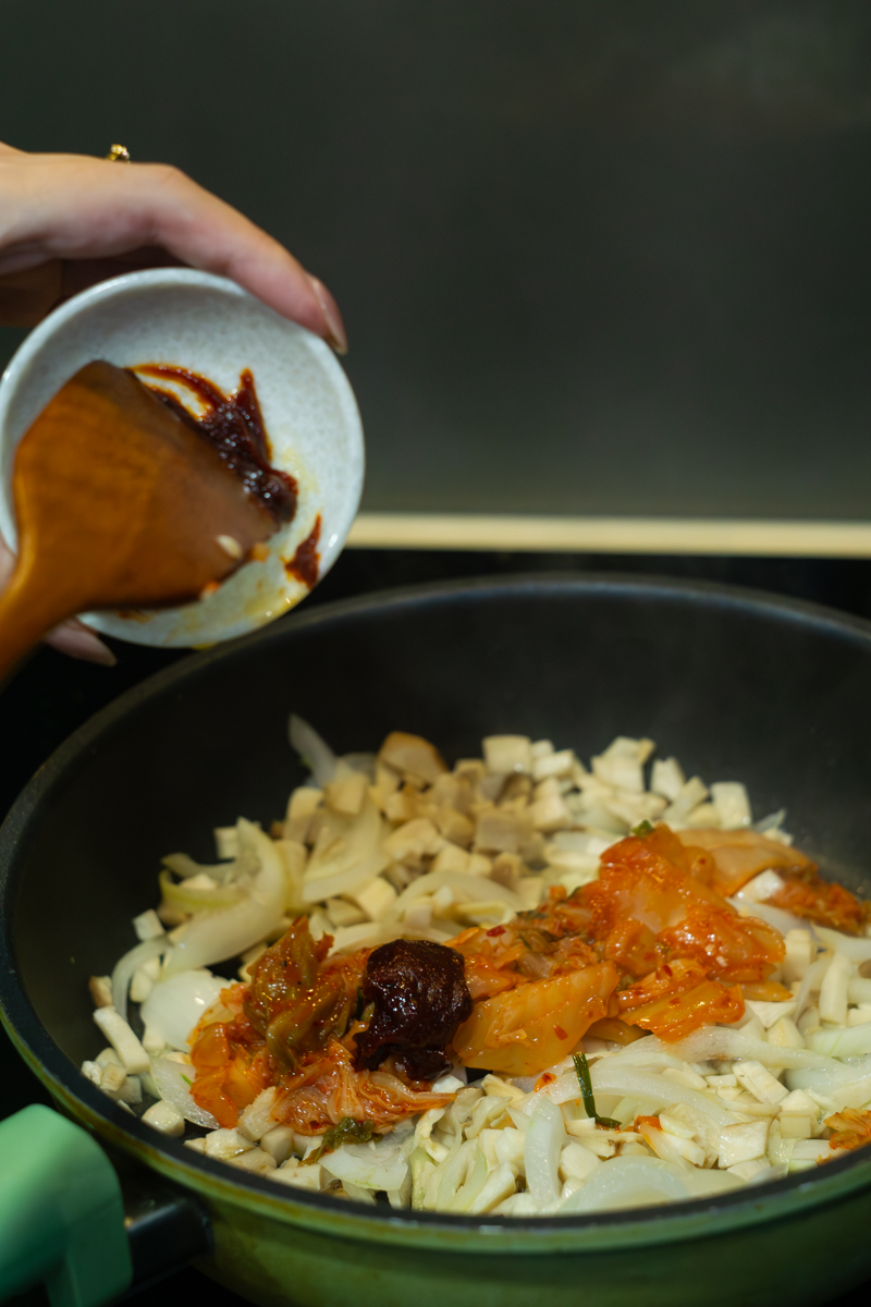 adding kimchi, gochujang and soy sauce