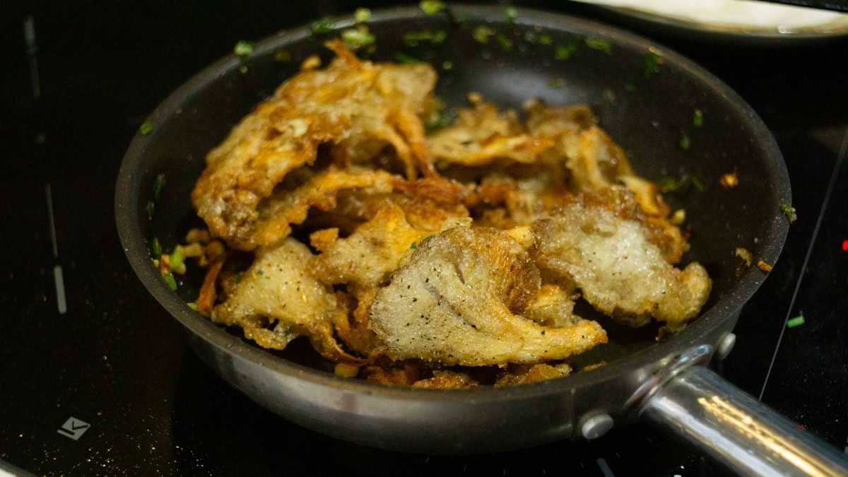 salt and pepper mushroom sizzling in a pan
