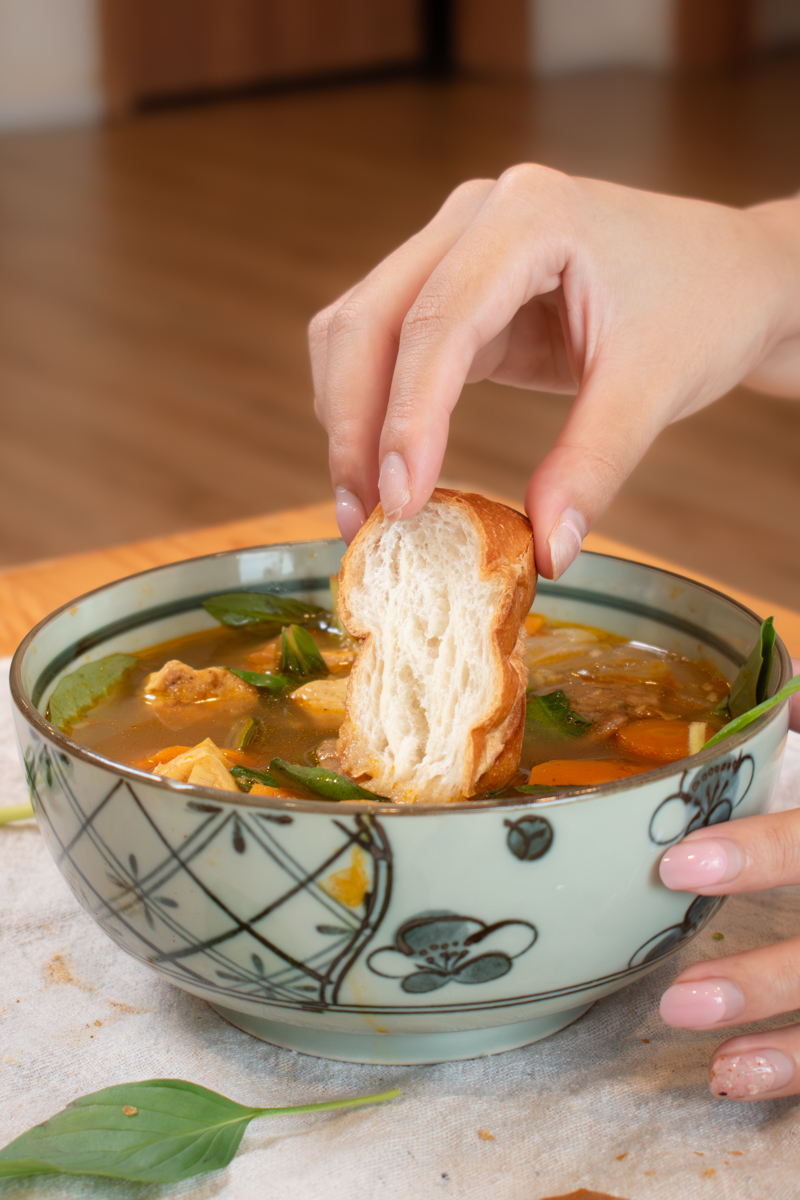dipping bánh mì in vegan vietnamese beef stew